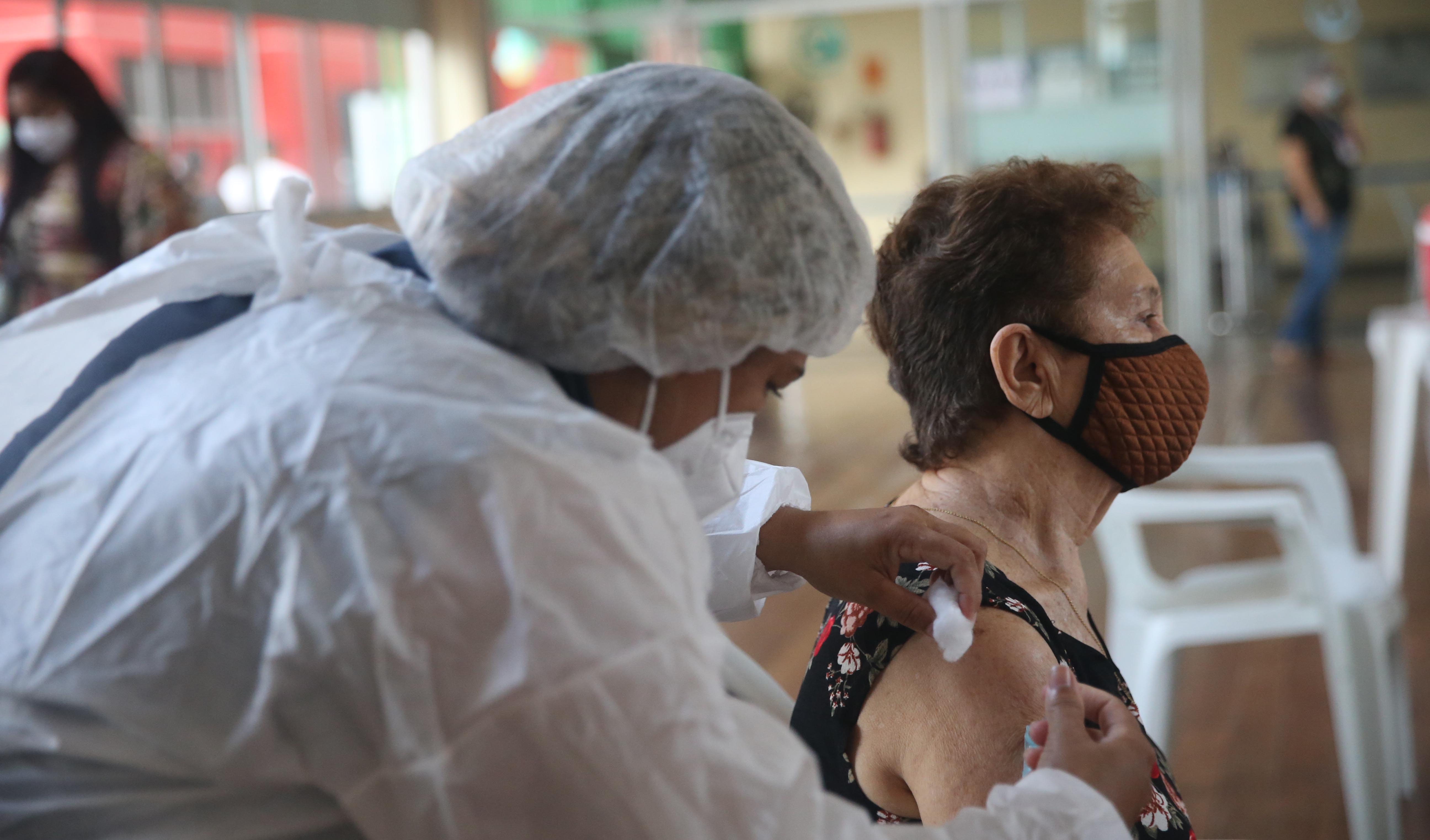 enfermeira vacina uma senhora